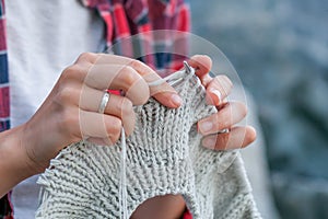 Young woman knits a sweater