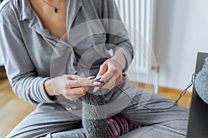 young woman knits wool product