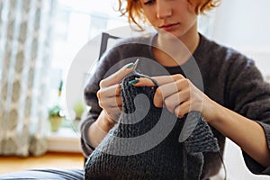 young woman knits wool product