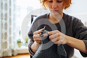 young woman knits wool product