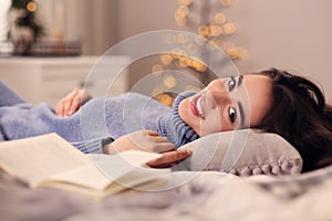 Young woman in knitted sweater resting at home. Winter atmosphere