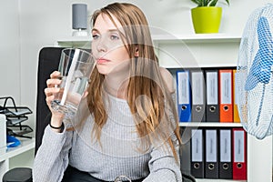 Young woman is knocked off heat in the office