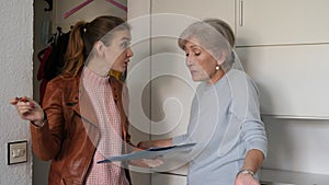 Young woman landlord and senior woman tenant discussing problem