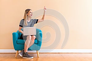 Young woman with a laptop computer pointing something photo