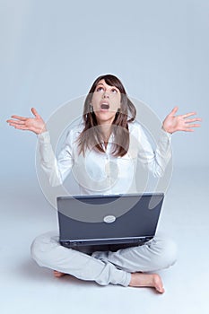 Young woman with laptop on the floor looking up