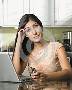 Young Woman With Laptop and Holding Cellphone