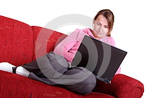 Young woman with laptop on red couch