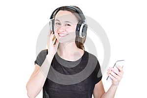 Young woman laughing and listening to music with earphones and smart phone