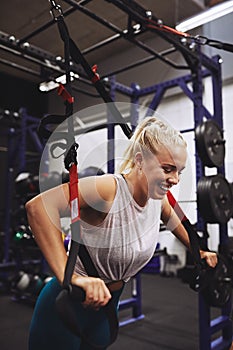 Young woman laughing while working out at the gym