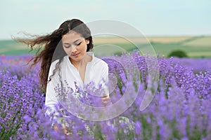 Young woman is in the lavender field, beautiful summer landscape with red poppy flowers