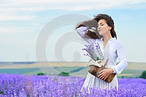 Young woman is in the lavender flower field, beautiful summer landscape