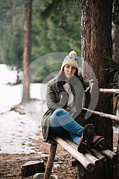 Young woman laying on a bench in the forest