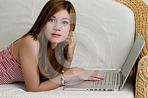 Young woman laying down with computer