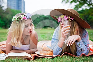 Young woman laying down on mat and grass field with friend