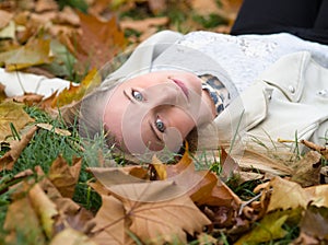 Young Woman Laying in the Grass in Autumn Park