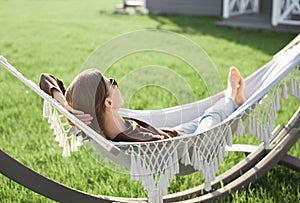 Young woman laying in hammock, enjoying life, summer lifestyle concept