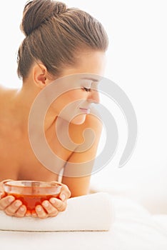 Young woman laying on massage table with honey plate