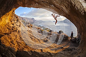 Young woman lead climbing in cave