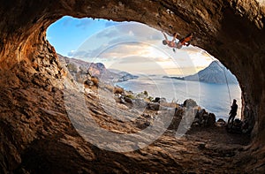 Young woman lead climbing in cave