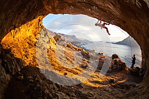 Young woman lead climbing in cave