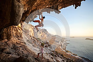 Young woman lead climbing in cave