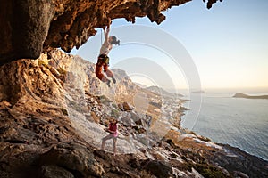 Young woman lead climbing on overhanging cliff photo