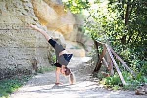 A young woman leading a healthy lifestyle and practicing yoga, performs the Urdhwa Prasarita Ekapadasana exercise