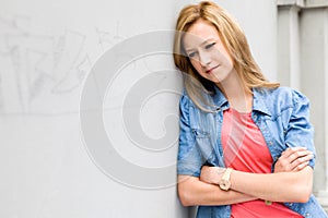 Young woman leaning against wall