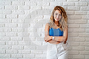 Young woman leans back to the wall and looking to a point wiyh a smily face.