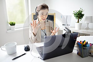 Young woman is learning language with laptop computer, camcorder and headphone online at home. Student is having video conference