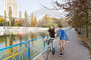 Young Woman Learning to Ride Bike on Park Bridge