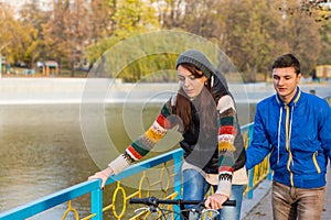 Young Woman Learning to Ride Bike on Park Bridge