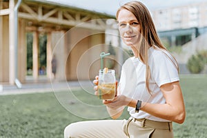 Young woman with lemonade outdoors