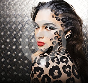 Young woman with leopard make up all over body, cat bodyart