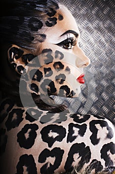 Young woman with leopard make up all over body, cat bodyart, halloween look