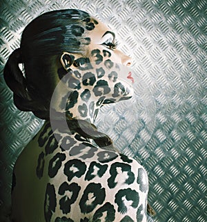Young woman with leopard make up all over body, cat bodyart print closeup