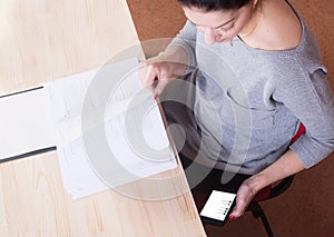 Young woman at the lessons waste her time on social network.