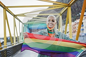 Young woman lgbt rainbow flag outdoor during coronavirus outbreak - Focus on face