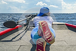 Young woman lie on fishing boat with fish finder, echolot, sonar aboard photo
