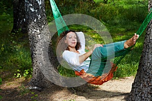 Young woman lies with dreamy view in hammock