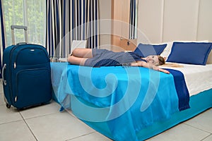 Young woman lies and has a rest on the bed in the hotel room.Rest after a long journey.