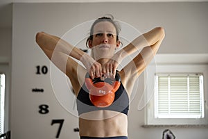 Young woman lifting kettlebell weight