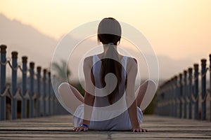 Young woman in light dress relaxing on warm sunny morning on sea shore. Summer vacation and travelling concept