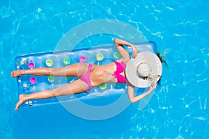 Young woman on a lilo in the swimming pool