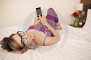 Young woman listen music using earphones and smartphone