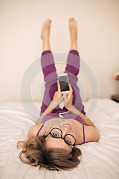 Young woman listen music using earphones and smartphone