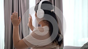 Young woman listen to music with headphone and dance in the living room at home