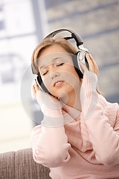 Young woman listening music on headphones