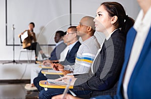 Young woman listening to lecture at business conference