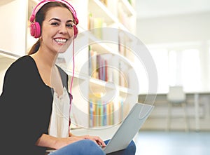 Young woman listening to music as she studies